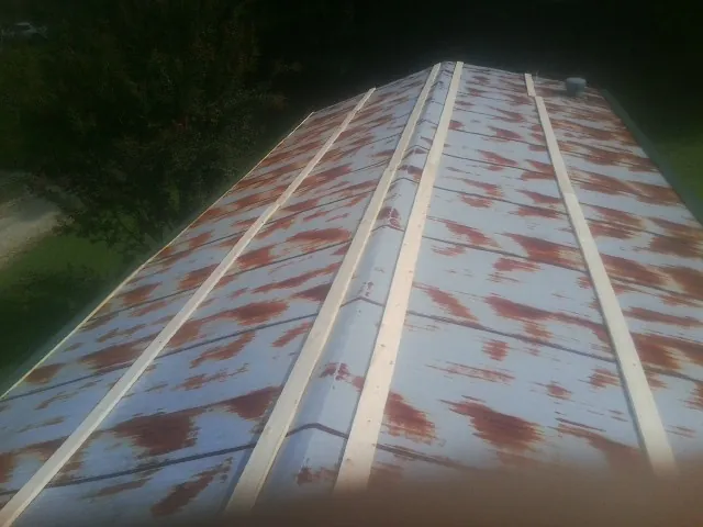 Rusted metal roof panels with new wood purlins before replacement — Storm Damage Roof Repair in Kohler by Roofing Brothers