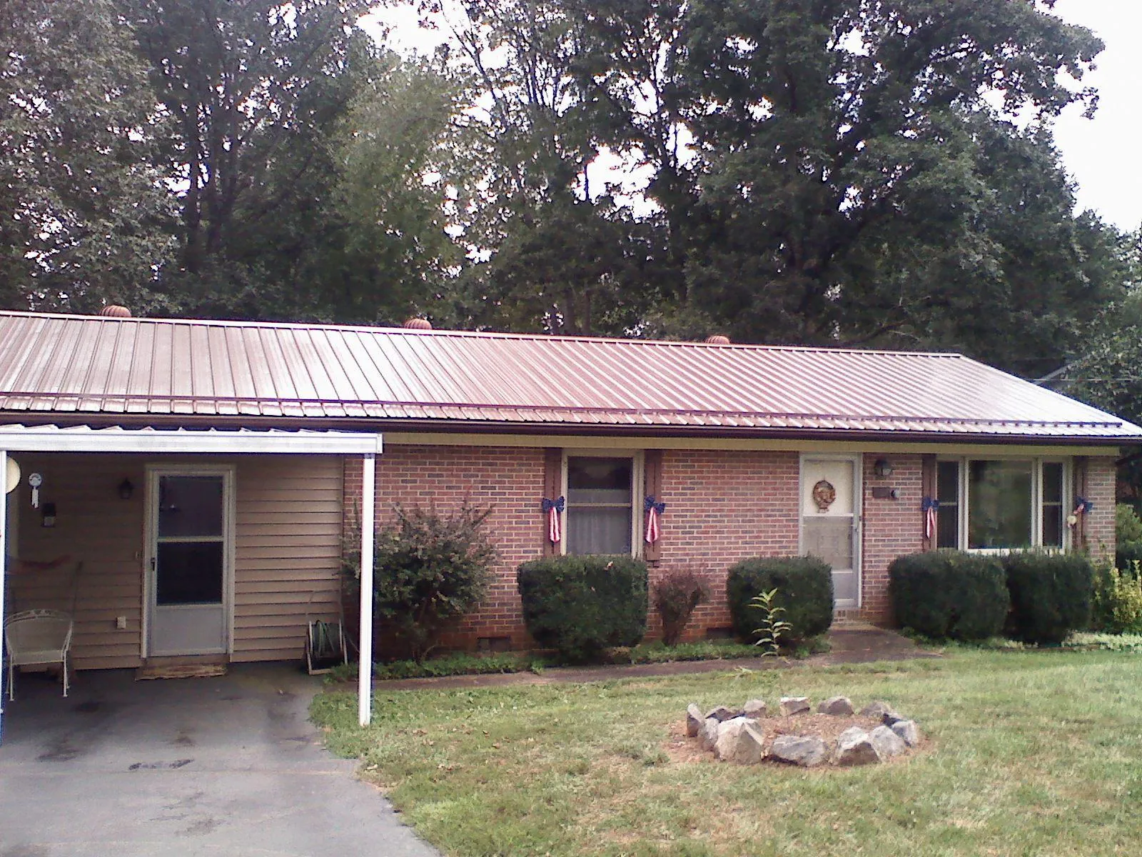 Bronze metal roof and carport on a brick ranch home — Roof Repair work by our crew in Kohler